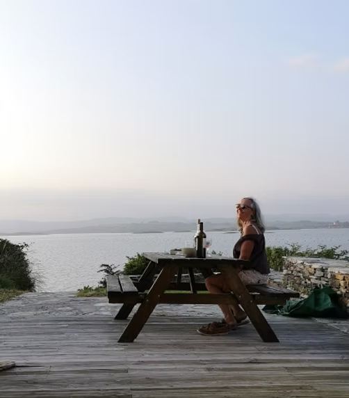 The owner at a table on the terrace overlooking the bay
